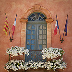 Mairie de Rousillon : fenêtre et drapeaux par Ann McLeod Images - Roussillon 84220 Vaucluse Provence France